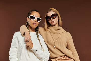 A joyful lesbian couple enjoys the autumn season while dressed in stylish sweaters and sunglasses.