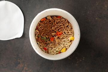 A top down view of dry instant ramen inside a cup package.