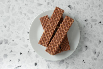 A top down view of a pile of chocolate wafer bars, on a plate.
