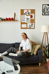 A young man smiles while sitting comfortably on a couch in a beautifully decorated room.