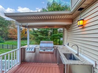 outdoor kitchen with granite countertops, grill and sink