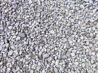 Gray gravel spread across a construction site on a sunny day