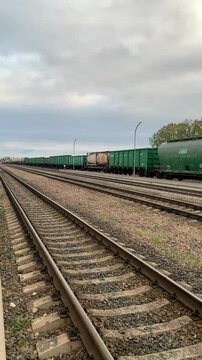 A train with freight cars travels along the railway