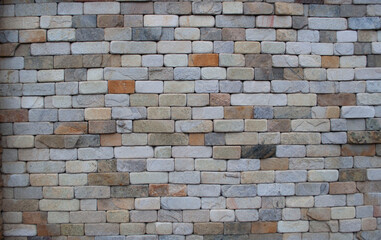 Obraz premium Colorful thin cut stone brick wall with streams of water running down the surface
