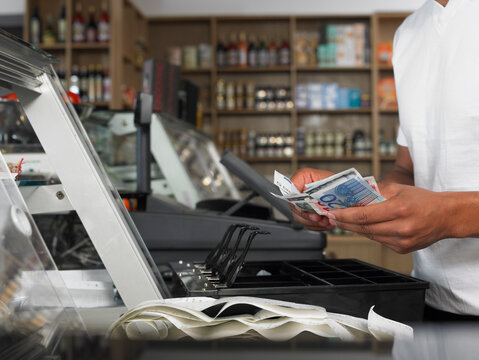 Man Counting Cash in Register