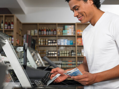 Man Counting Cash in Register