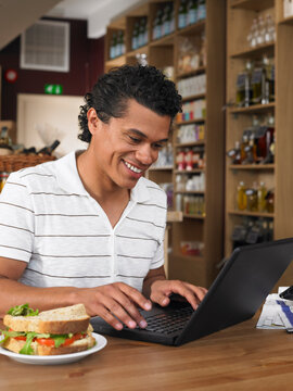 Man Using Laptop in Deli