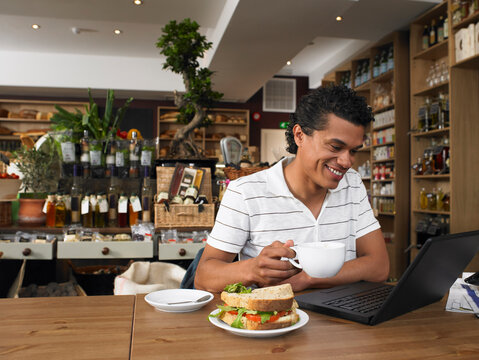 Man Using Laptop in Deli