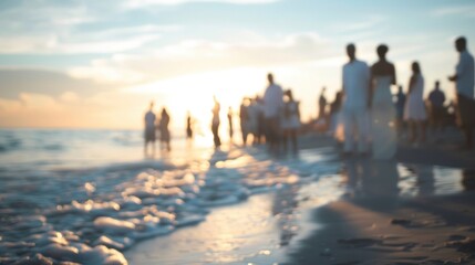 Blurred outlines of guests dressed in white standing on the shore for an intimate beach wedding.