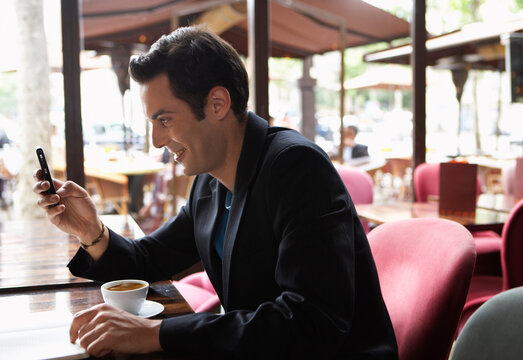 Man Using Cellphone in Cafe