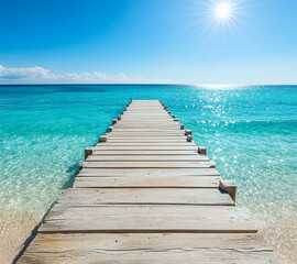 A wooden pier is in front of a beautiful blue ocean. The sky is cloudy, but the water is calm and clear.