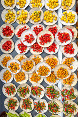 Peppers, various types and colors, viewed from above, for sale at an open-air market in Brazil.