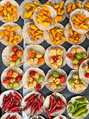 Peppers, various types and colors, viewed from above, for sale at an open-air market in Brazil.