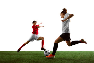 Two young women, female soccer players challenge each other for ball, competing for victory on field. Determination, motivation and focus. Concept of sport, action, competition, game