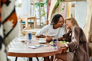 A joyful moment unfolds as two women enjoy a lunch date, sharing smiles and closeness in a quaint cafe