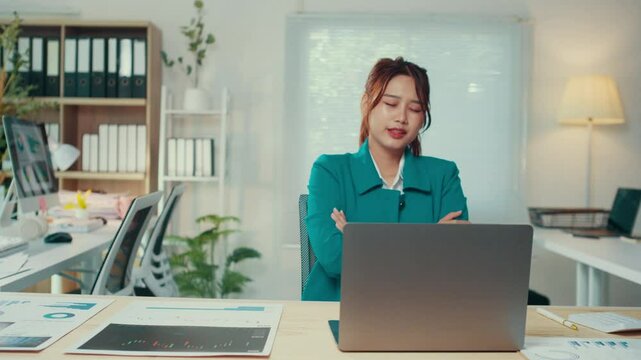 Young businesswoman sitting at her desk shows increasing stress and frustration while working on her laptop, reflecting the pressures of deadlines and the demands of her career