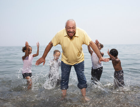 Man Being Splashed by Children in Lake