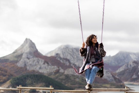 Joven columpi&aacute;ndose en Ria&ntilde;o (Mirador Alto Valcayo)