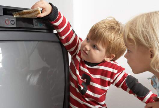Boy Putting Sandwich in VCR