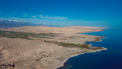 Aerial view of the serene coastline and mountainous landscape of Kyrgyzstans Issyk Kul region