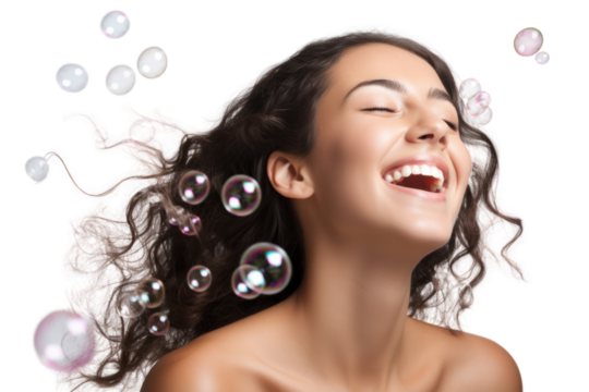 Close-up of a cheerful woman blowing a bubble with a playful smile as bubbles float around her isolated on white background
