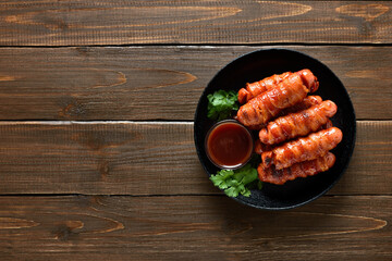 Bacon wrapped sausages with barbecue sauce