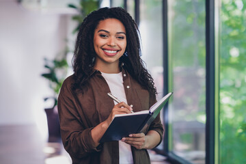 Photo of young woman corporate worker hold write pen notebook modern interior office indoors