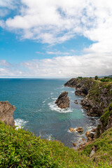 Spectacular natural lanscape in north of Spain, Asturias. Green coastline of Spain. High cliff. Turquoise water.  Waves breaking on the rock. Famous travel destination. 