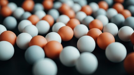 Naklejka premium Close-up of scattered orange and white textured balls on a dark surface, creating a pattern with varied focus.