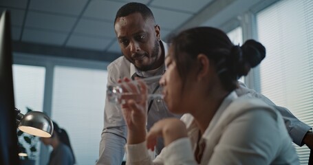 Call center office: Close up of tired Asian female helpdesk specialist holding head, feeling...
