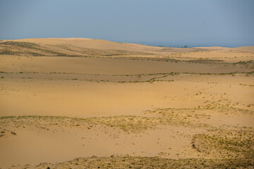 View of a sandy plateau surrounded by forest and mountains