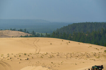 View of a sandy plateau surrounded by forest and mountains