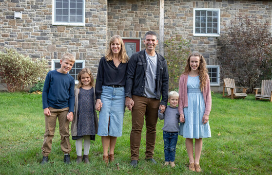 Portrait of a family standing in front of their house in Beckwith Township at Carleton Place in the Ottawa Valley; Ontario, Canada