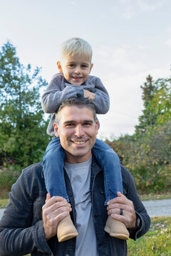 Portrait of a father carrying his son on his shoulders, smiling at the camera, Beckwith Township at Carleton Place in the Ottawa Valley; Ontario, Canada