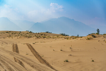 Golden desert dunes illuminated by sunbeams under a dramatic sky