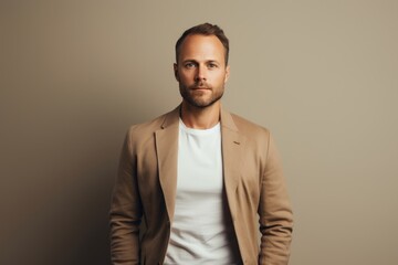 Obraz premium Portrait of a tender man in his 30s wearing a chic cardigan isolated on light wood minimalistic setup