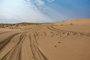Golden desert dunes illuminated by sunbeams under a dramatic sky