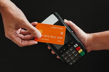 Close up hand doing contactless payment using credit card on EDC machine. Cashless, touchless, modern wireless payment, financial and business concept.