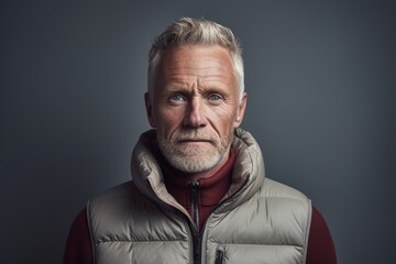 Obraz premium Portrait of a glad man in his 50s dressed in a water-resistant gilet in front of light wood minimalistic setup