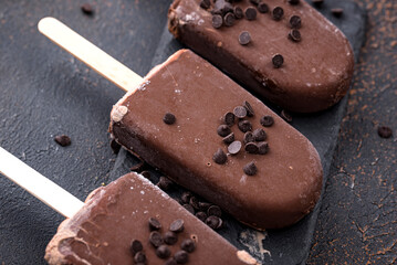 Delicious chocolate popsicles on dark background