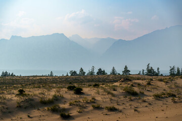 View of a sandy plateau surrounded by forest and mountains
