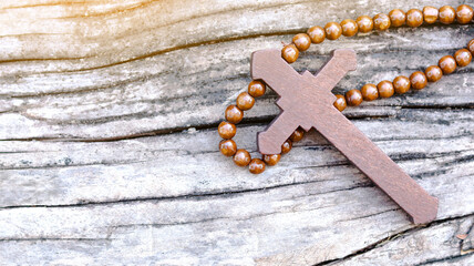 Dark red wooden cross on wooden background symbolizing the spread of Jesus Christs love among Christians reflecting faith devotion and the importance of Christian teachings.