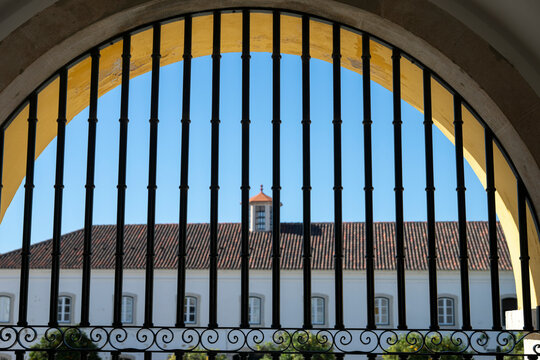 Architecture viewed through the vertical bars in an archway in the city of Faro, Portugal. Faro is the capital of southern Portugal&rsquo;s Algarve region; Faro, Faro, Portugal