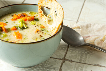 bowl of broccoli cheese soup on table