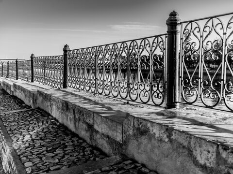 Decorative metal fence along a waterfront in the coastal town of Tavira, Portugal. Tavira is a small city on Portugal&rsquo;s Algarve coast and straddles the Gilao River; Tavira, Algarve region, Portugal