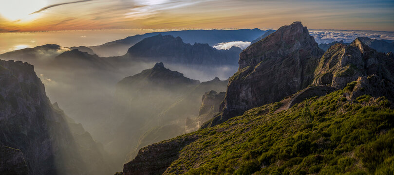 Sunset light from Pico do Areeiro, Madeira island's third highest peak, with the mountain range peaks in the clouds, Portugal; Sao Roque do Faial, Madeira, Portugal