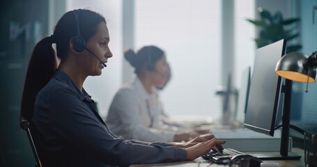 Call center office: Portrait of Caucasian hotline operator talking on headset with customer,...