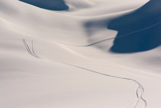 Wavy lines of snowboarding tracks on a fresh snow covered mountainside; Haines, Alaska, United States of America