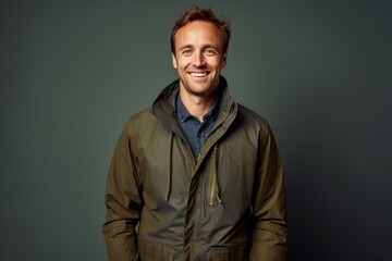 Obraz premium Portrait of a joyful man in his 30s dressed in a water-resistant gilet isolated in plain cyclorama studio wall