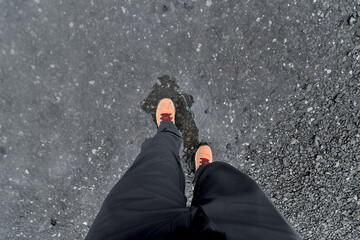 Hiker walking on wet asphalt after rain in the mountains